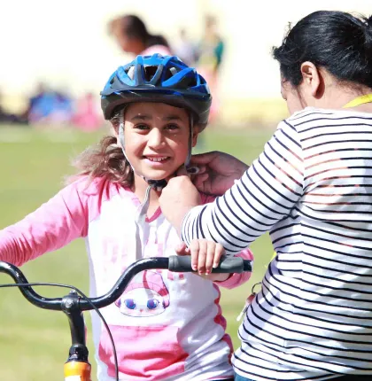 A girl having her helmet fitted before a ride